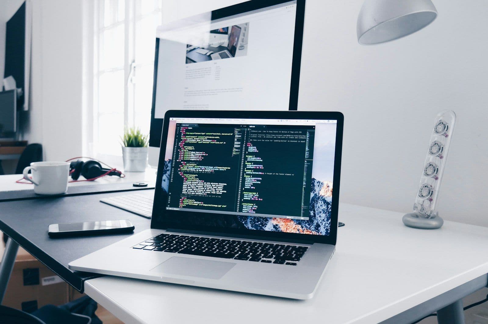 Software engineer working at a laptop with code on screen